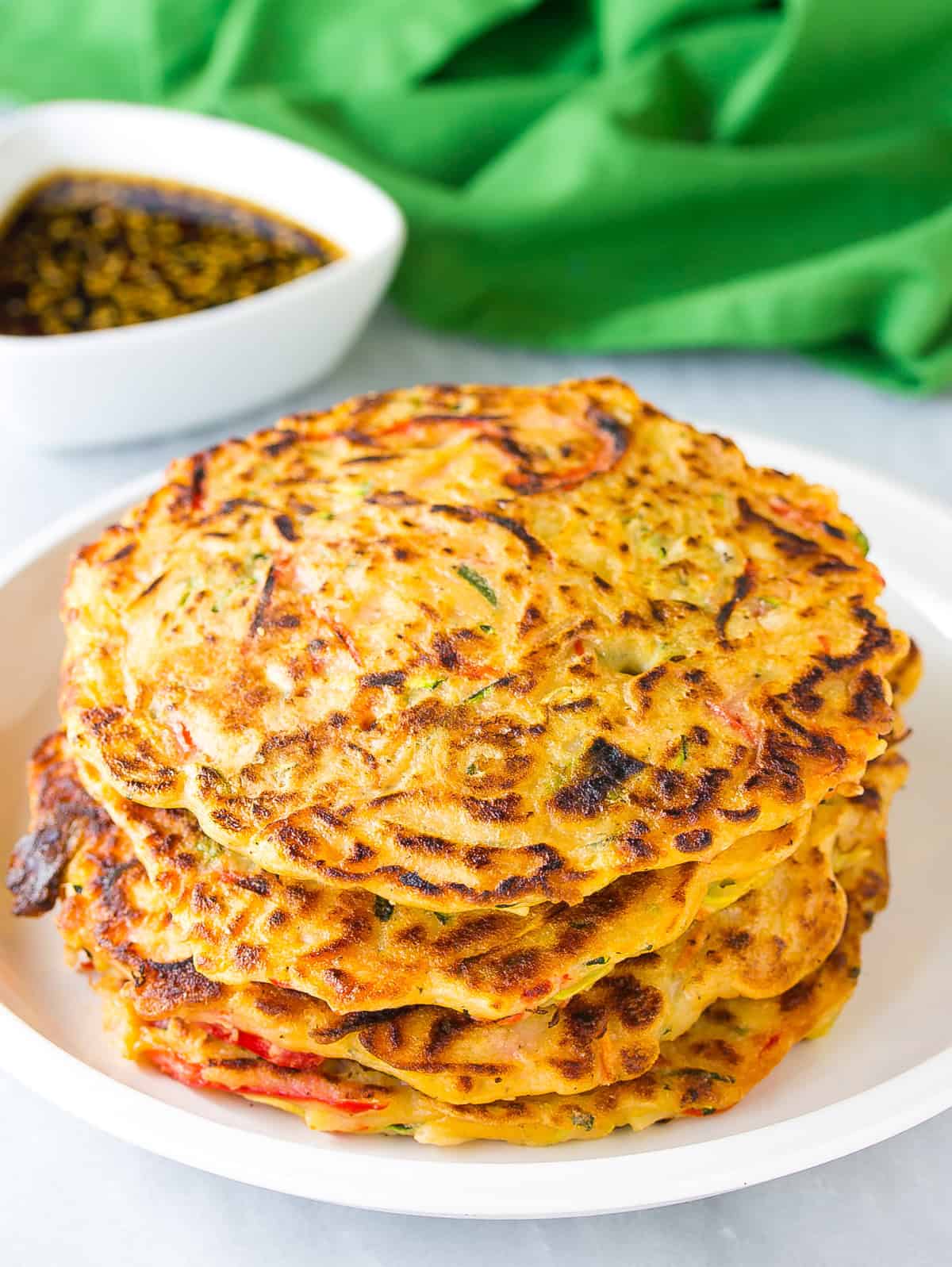 cooked korean pancake on plate with dipping sauce