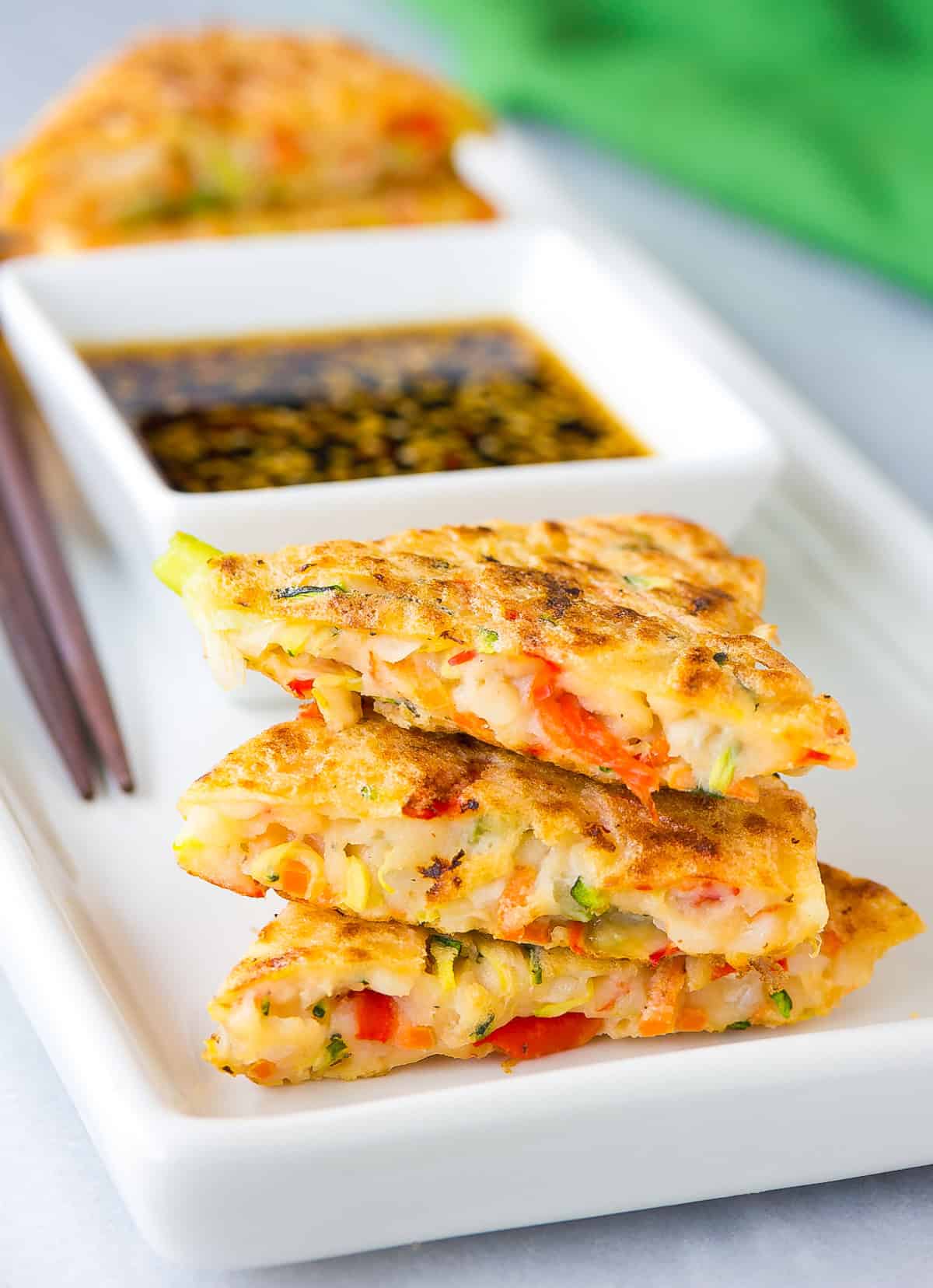 Korean Pancake Recipe #ASpicyPerspective #KoreanPancakes #KoreanPancakeRecipe #Pajun #Pajeon #Korean #Vegetarian Inside view of korean veggie pancakes served on a platter.