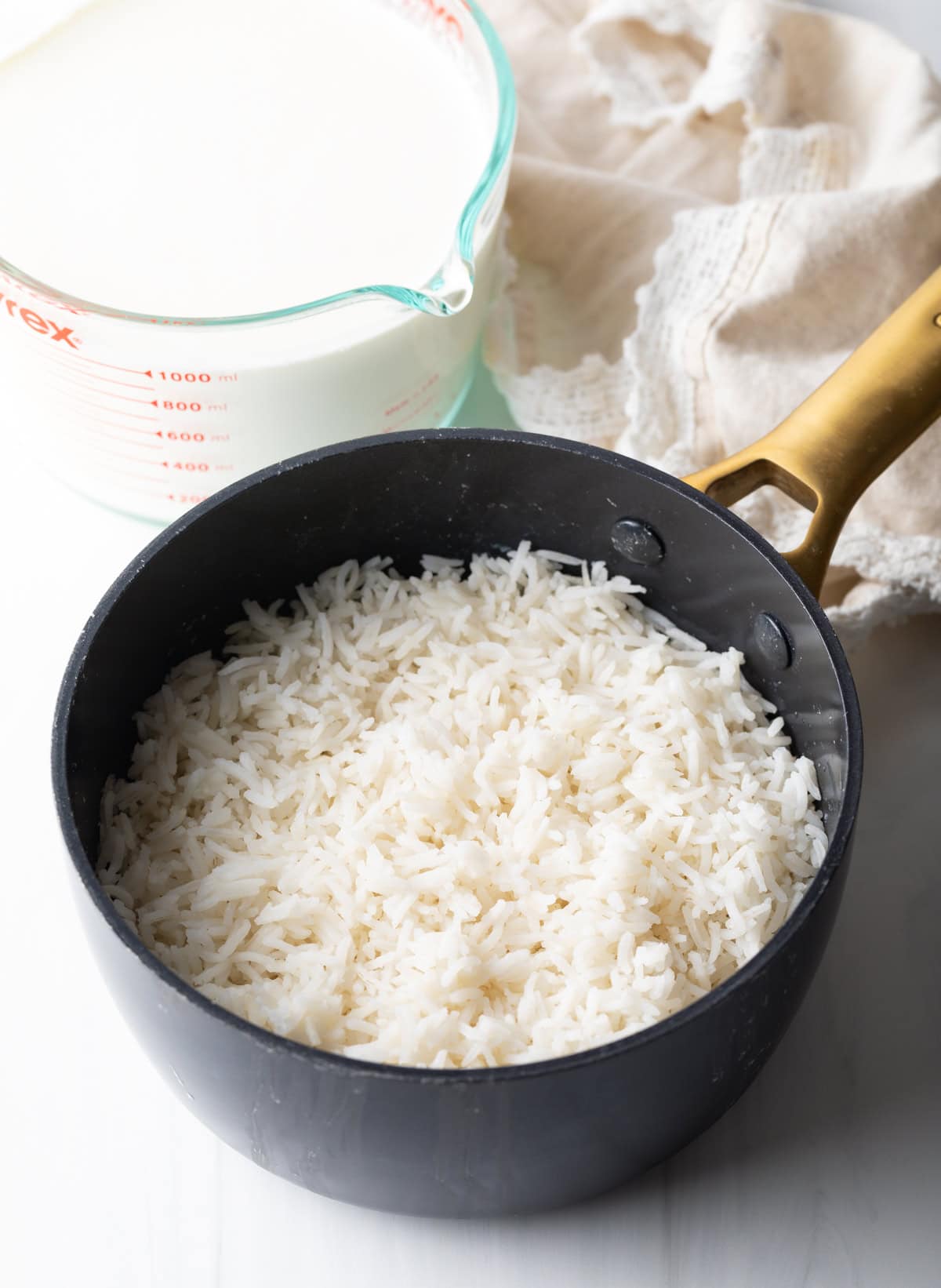 Pot filled with cooked and fluffed white rice.