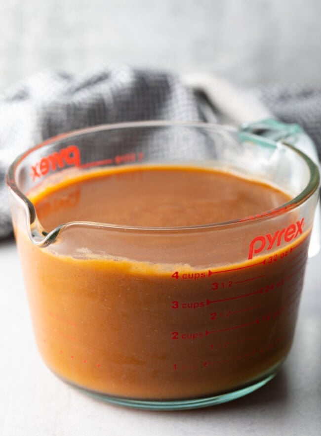 Strained Espagnole Sauce in a glass.