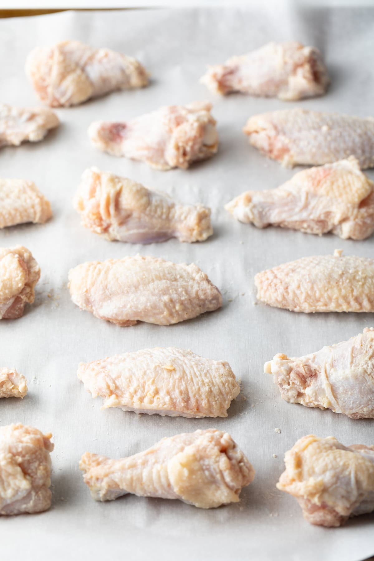 Raw chicken wings on a baking sheet.