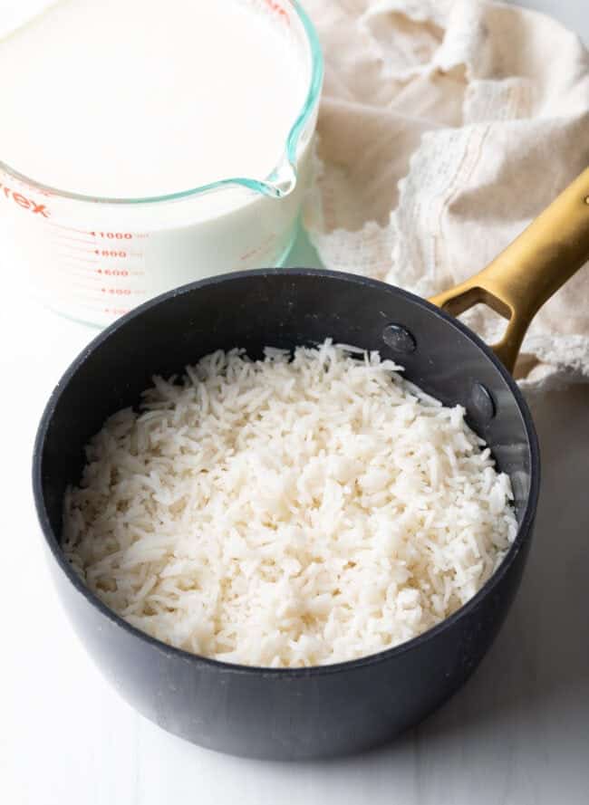 Small sauce pot with cooked white rice.
