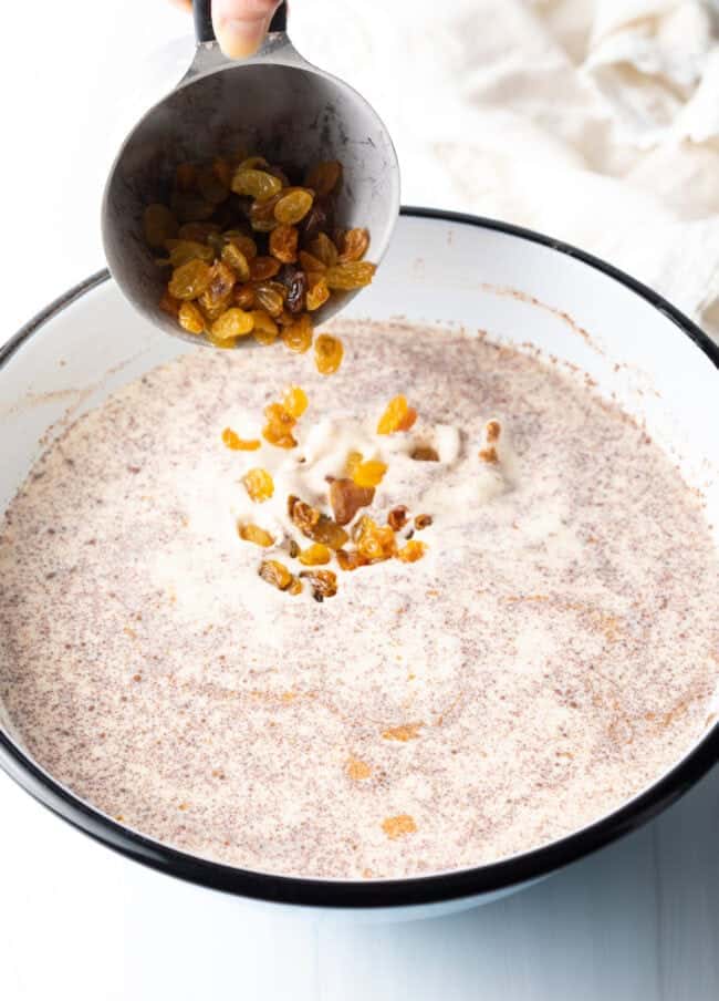 Adding golden raisins to the cream and rice mixture.
