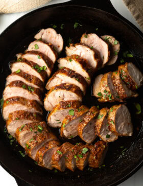 Cooked honey garlic pork tenderloin out from roasted. Chops sliced in cast iron skillet.