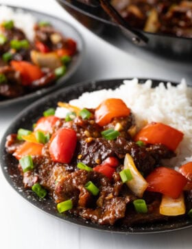 Side view Beijing beef in a bowl with rice.