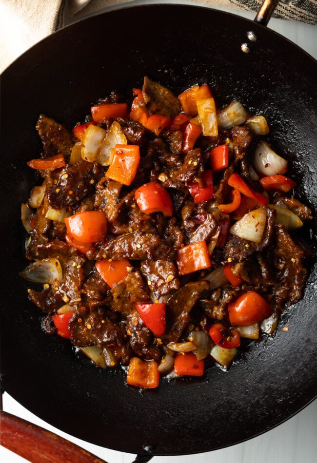 Top down view stir fry beef with veggies in a wok.