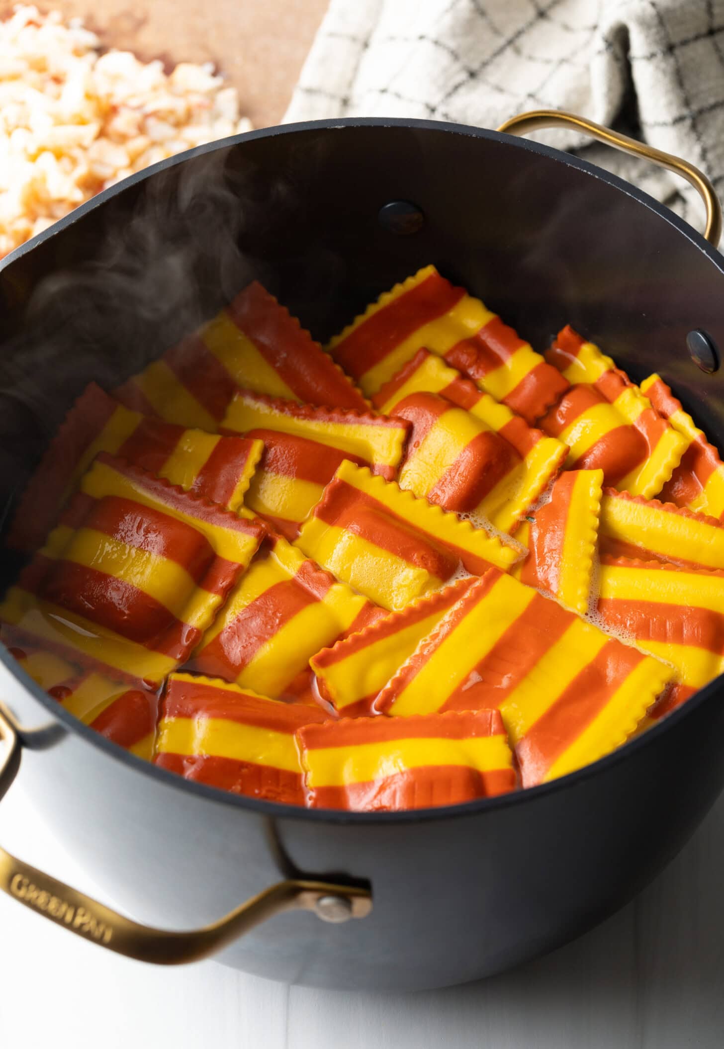 Lobster ravioli in a stock pot after being drained.