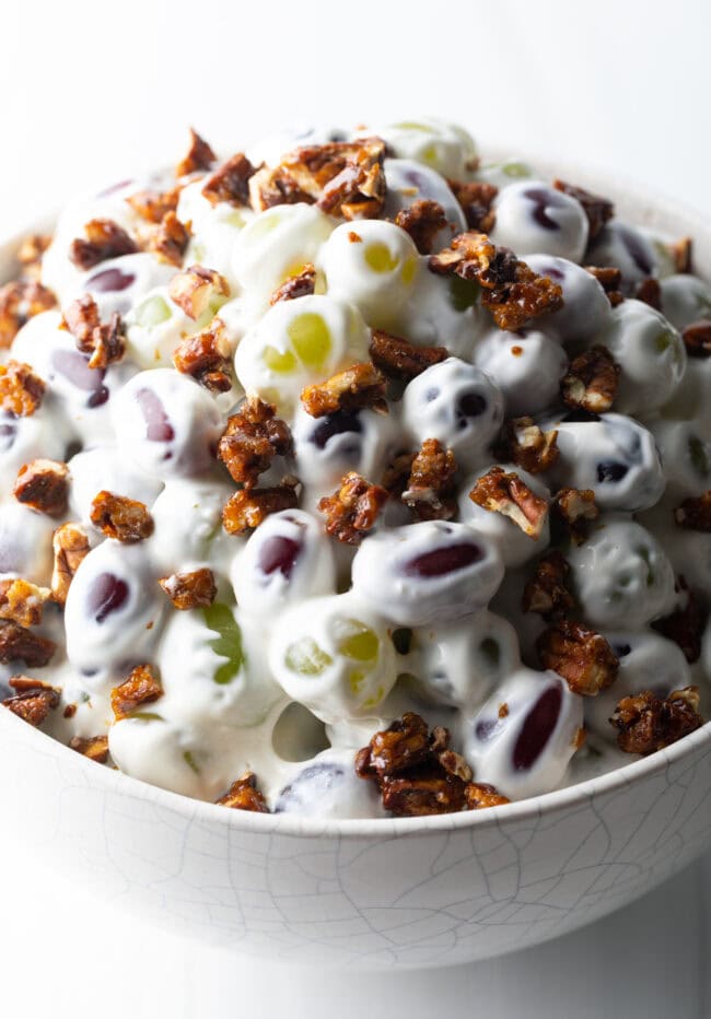 Close top down view salad made with green and red grapes, cream cheese, and pecans.