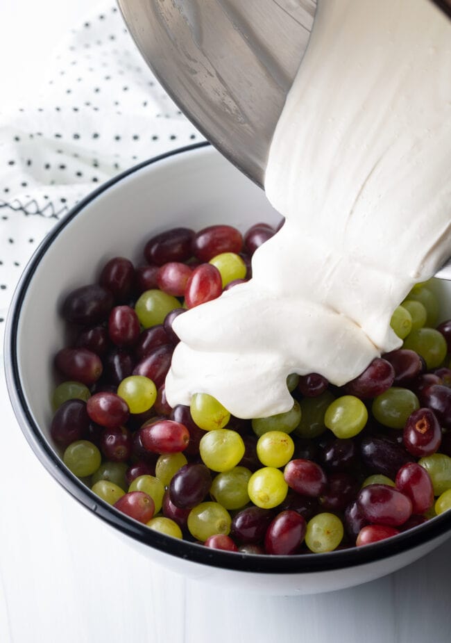 Pouring the cream cheese mixture into the fruit bowl.