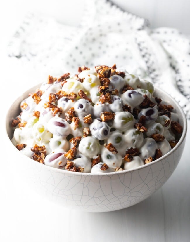 Side view of grape salad in a white bowl.