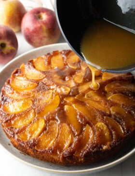 Pouring whiskey sauce onto the apple cake.