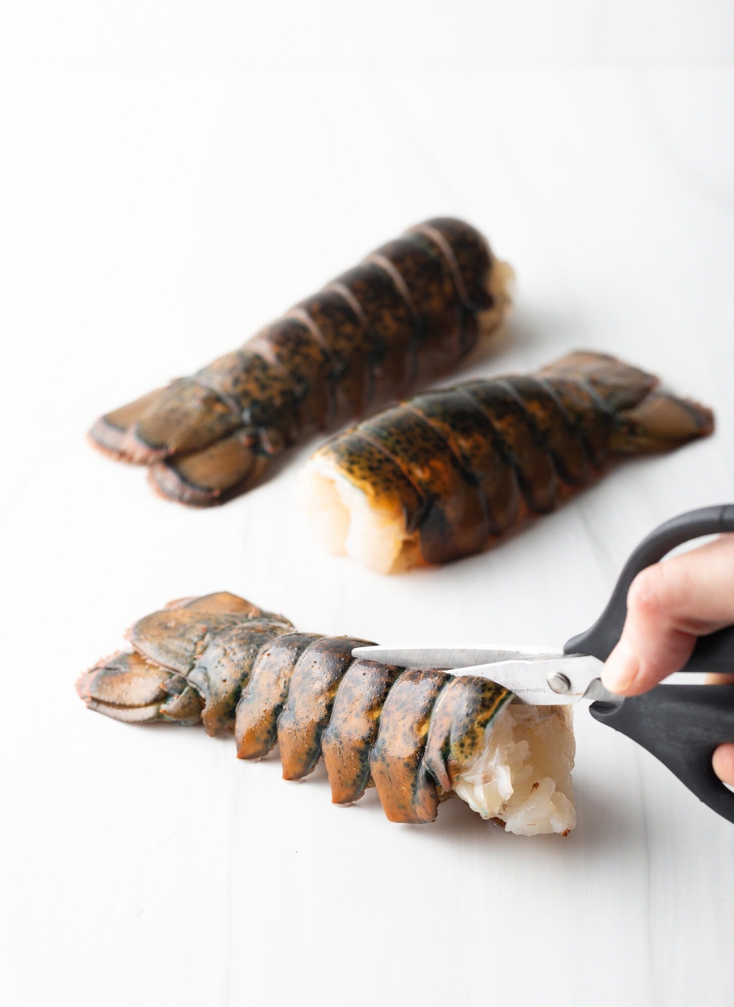 Using kitchen shears to cut the shell in half lengthwise.