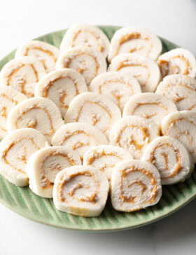 Green plate filled with round peanut butter potato candy slices.