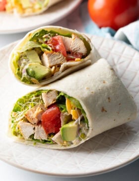 Top down view loaded chicken wrap, two pieces of the wrap are lying criss cross on each other.
