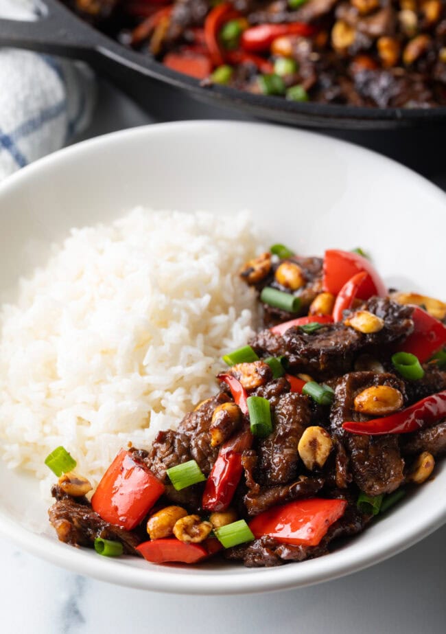 Kung pao beef stir fry served in a white bowl with white rice.