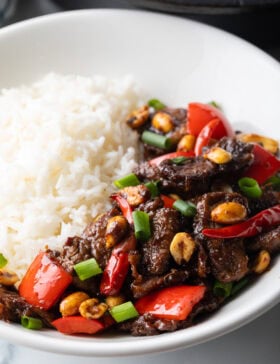 Kung pao beef stir fry serving in a white bowl with white rice.