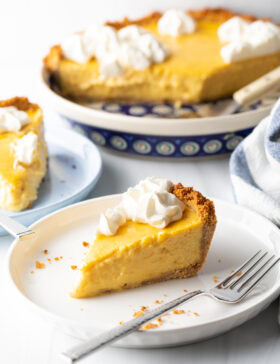 Slices of mango tart on a white plate, metal fork to the side.