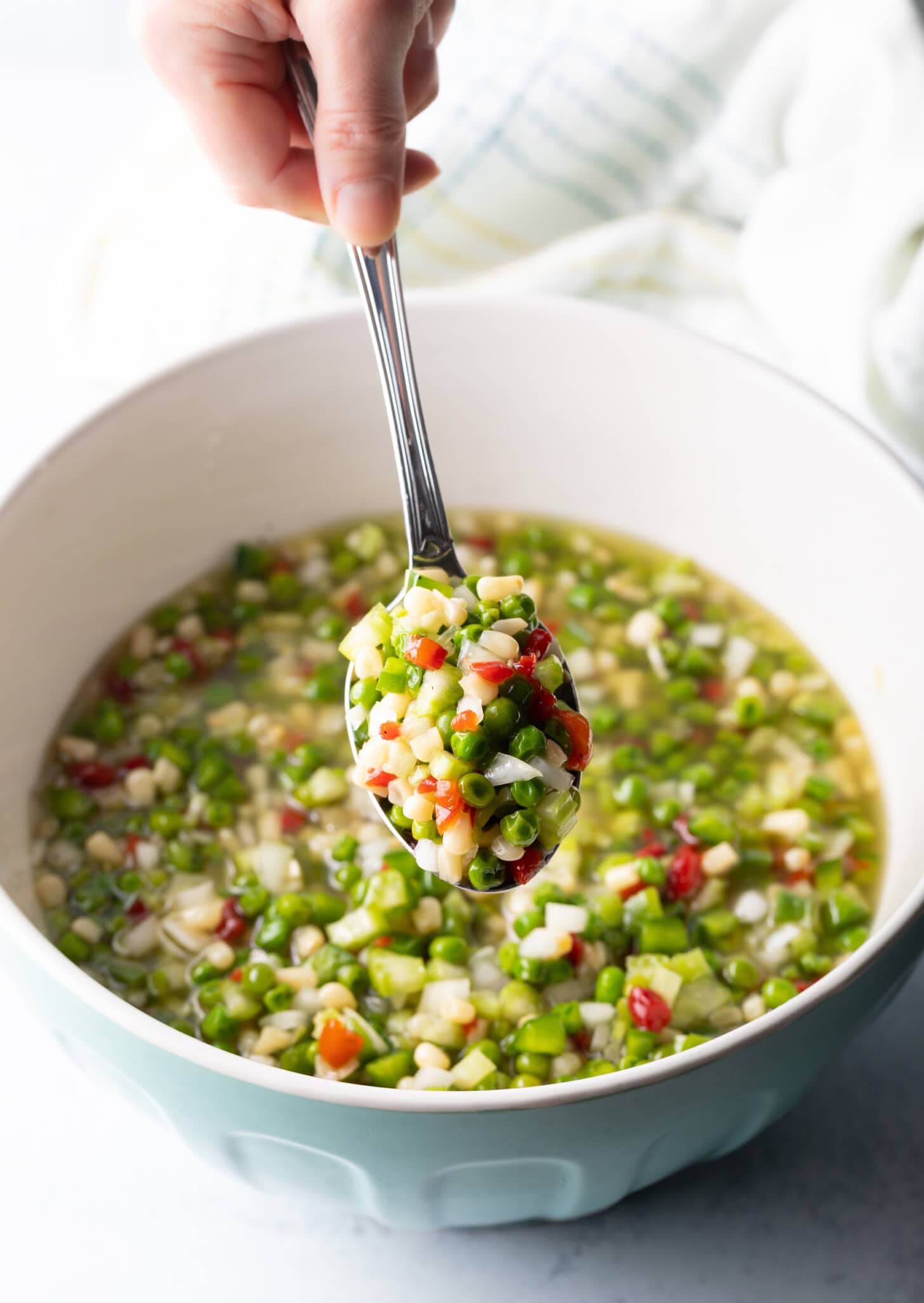 Metal spoon showing scoop of veggie salad to camera.