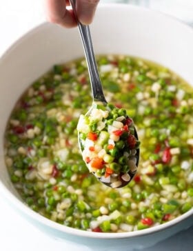 Metal spoon showing scoop of veggie salad to camera.