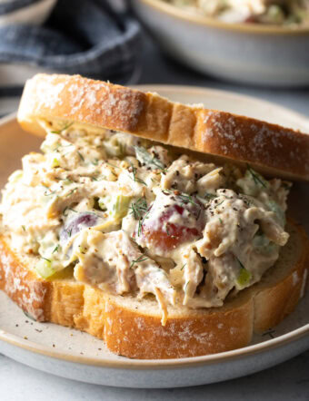 Large turkey salad sandwich on a white plate.