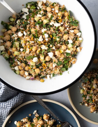Large white bowl filled with bulgar wheat, veggies, and feta salad.