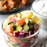 Chopped kachumber India salad in a glass bowl.