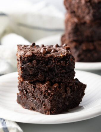 Two collagen protein brownies stacked on a white plate.