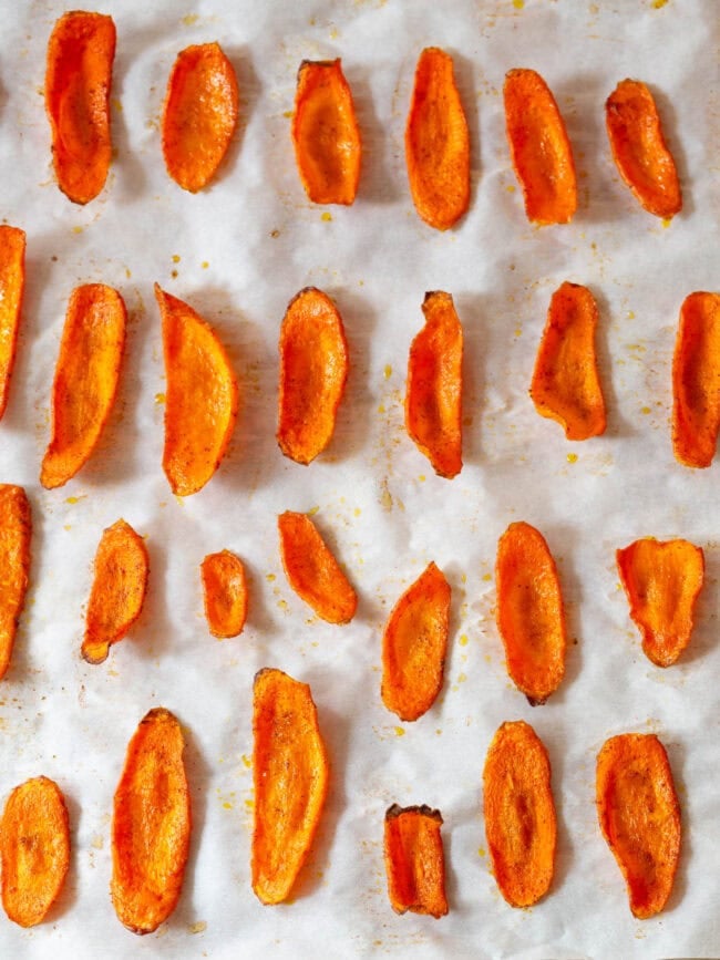 Baked carrot slices on baking sheet. 