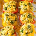 Rice stuffed peppers with cheese and broccoli in a baking dish