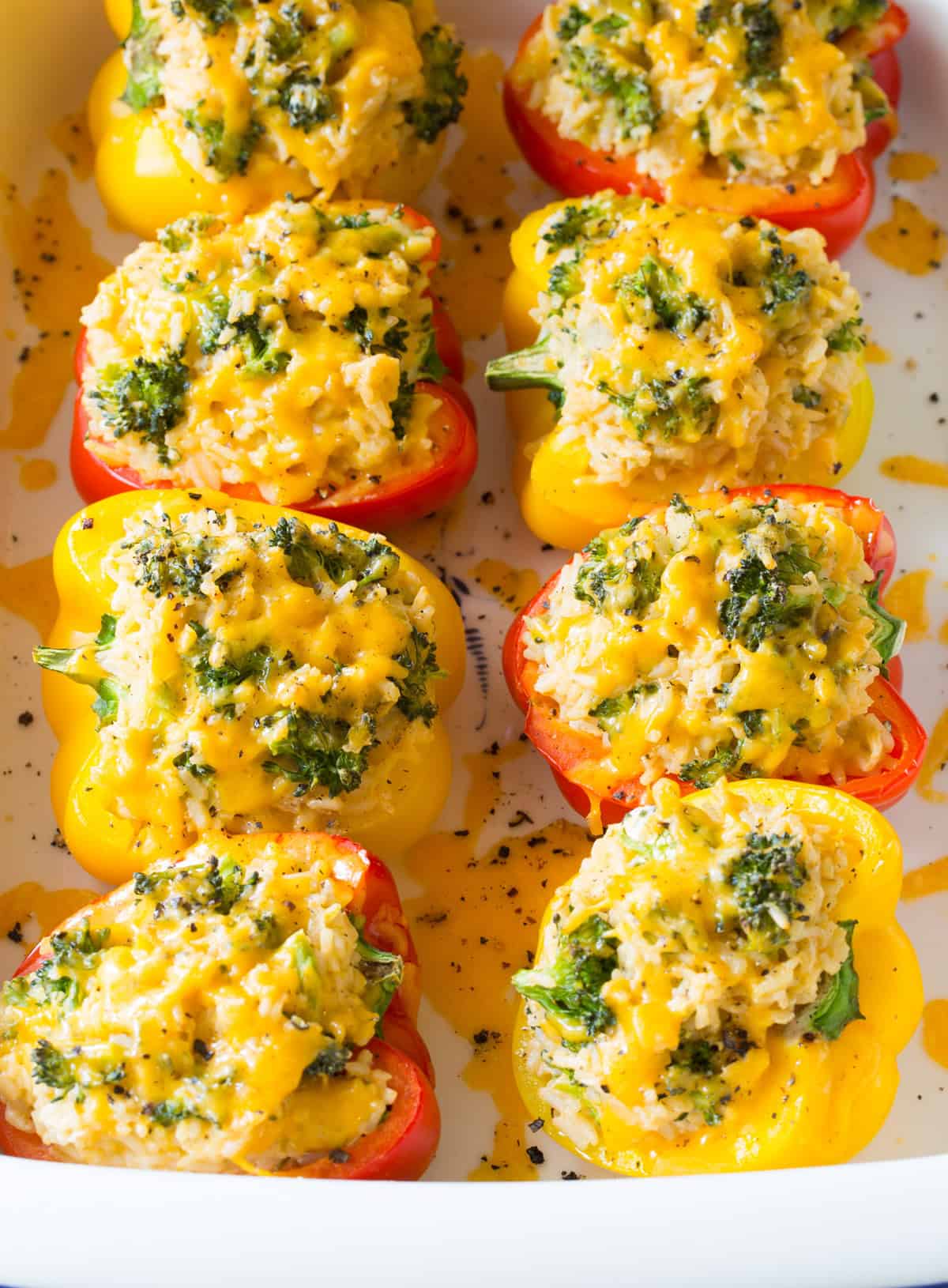 Rice stuffed peppers with cheese and broccoli in a baking dish