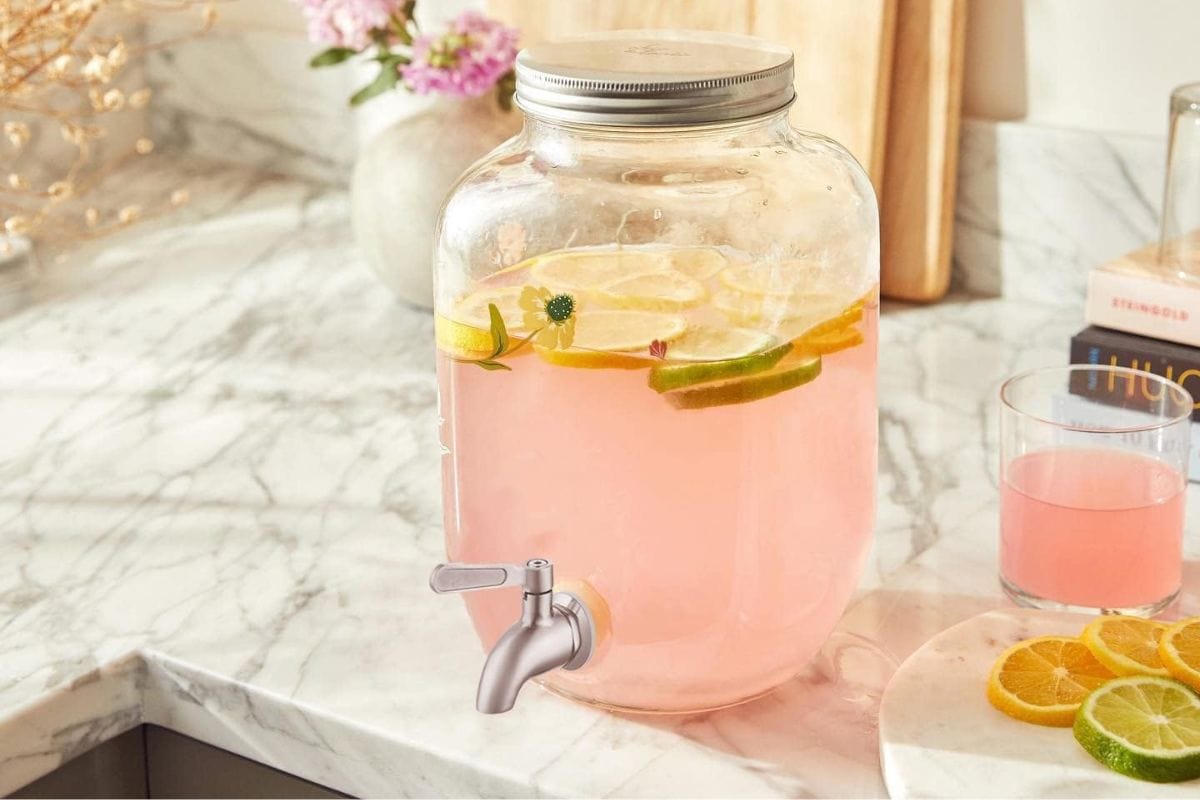 Le'Raze Glass Beverage Dispenser on a kitchen counter with pink lemonade in it.  