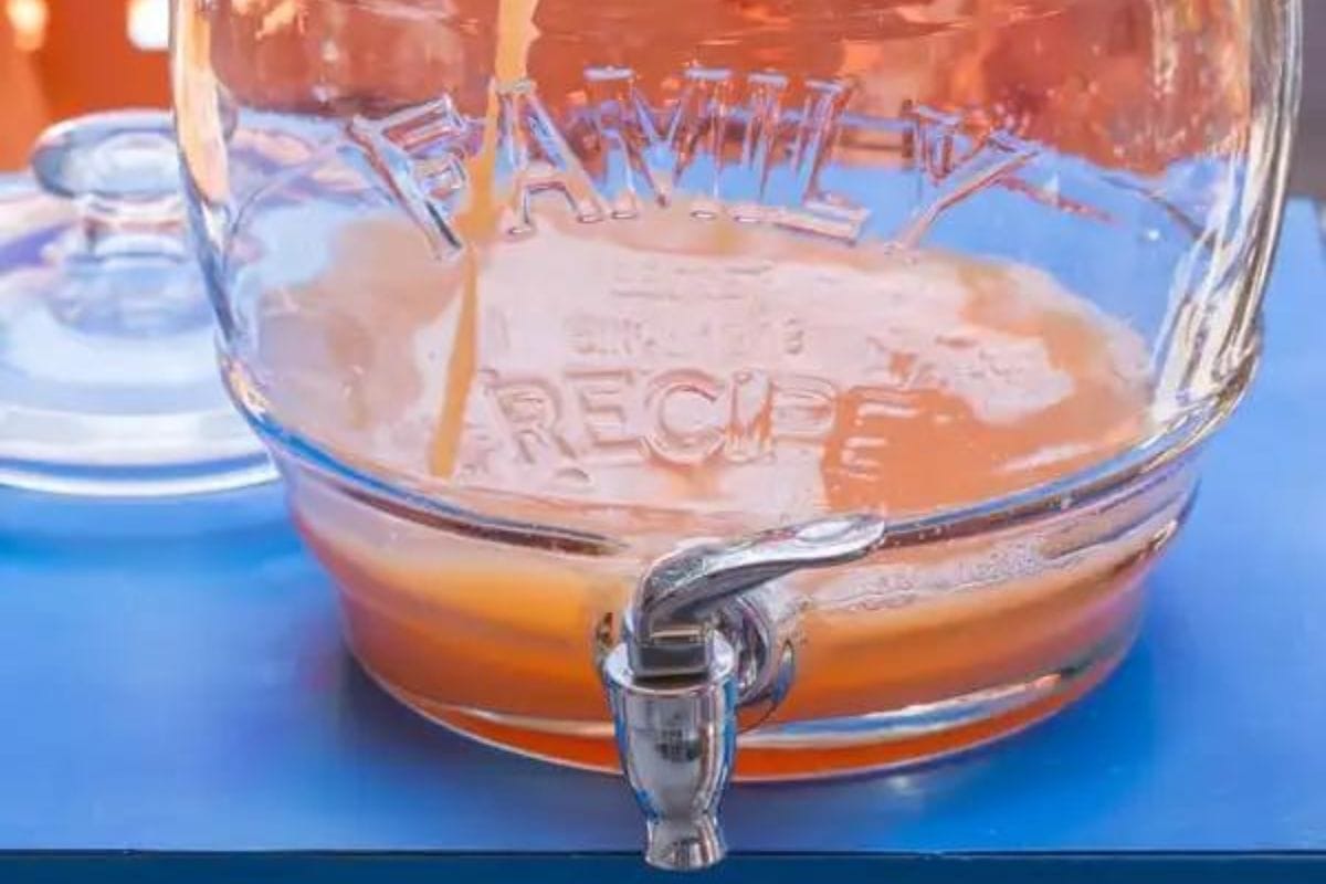 Bahamian Blast Batch Cocktail being poured into a glass drink dispenser. 