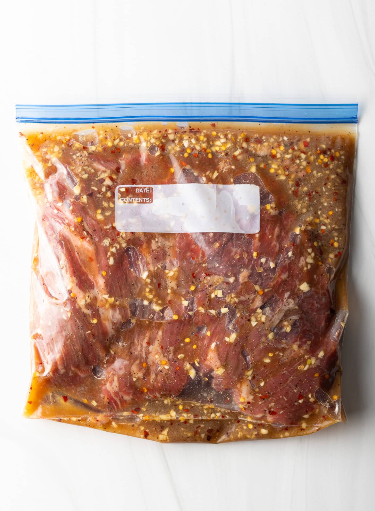Raw meat in a ziploc bag with marinade.