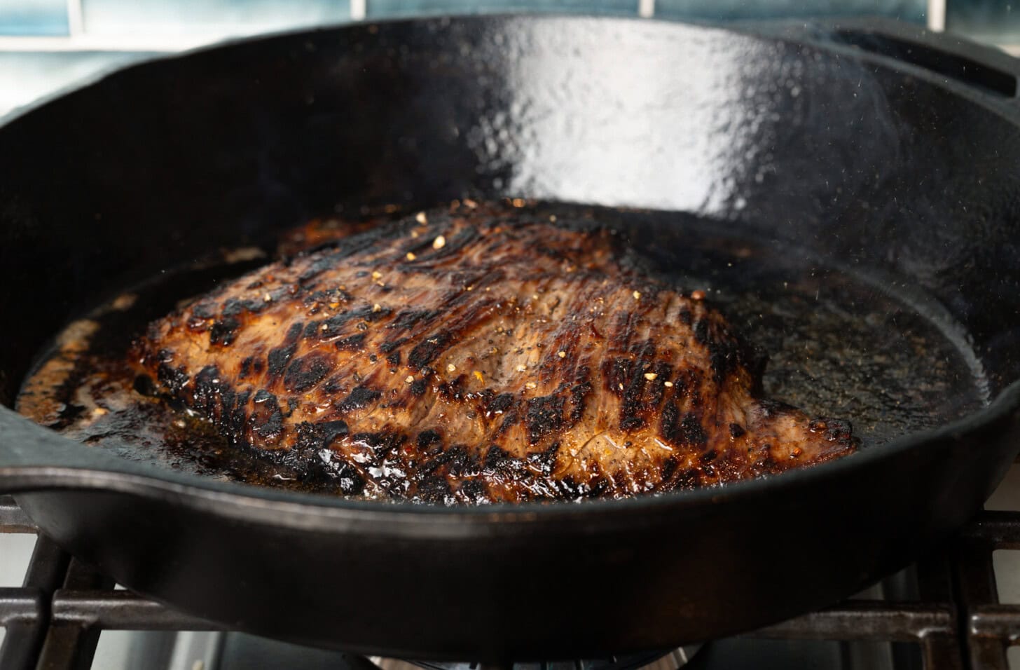 Searing a steak in a cast iron pan.