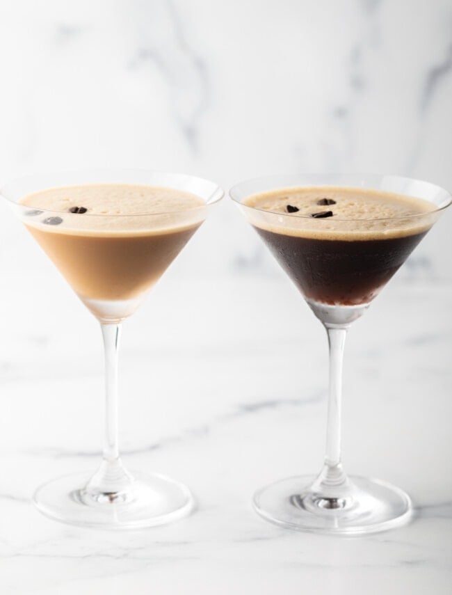 Best Espresso Martini Recipe - Two espresso martinis in individual glasses, one creamy and one dark. Each glass is garnished with 3 coffee beans. Both are on a white background.