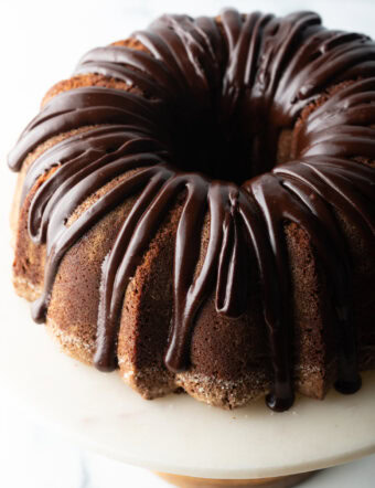 Top down view, circular chocolate sour cream bundt cake with a thick chocolate glaze drizzled on top.