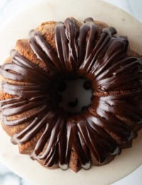 Top down view, circular chocolate sour cream bundt cake with a thick chocolate glaze drizzled on top.