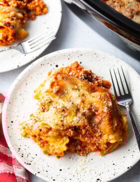 White plates with servings of slow cooker ravioli lasagna casserole.