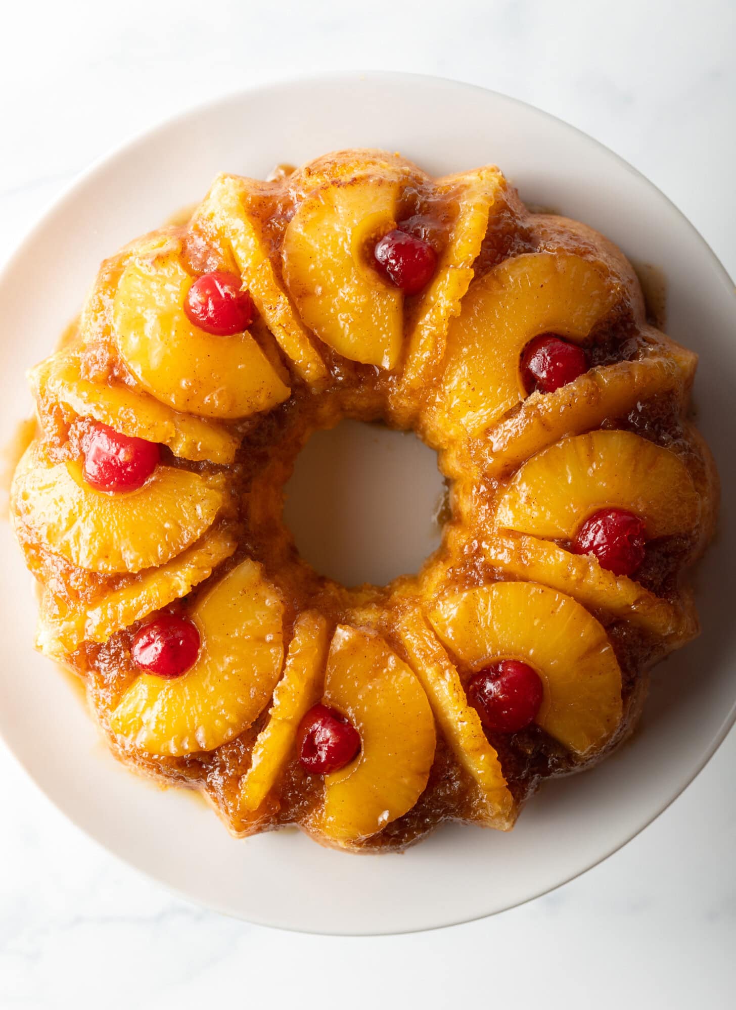Top down view of pineapple upside down bundt cake topped with cherries.