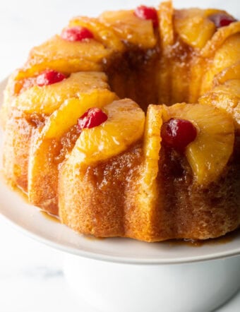 Close view pineapple upside down bundt cake topped with cherries.