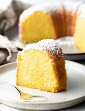 Slice of yellow cake on a white plate.