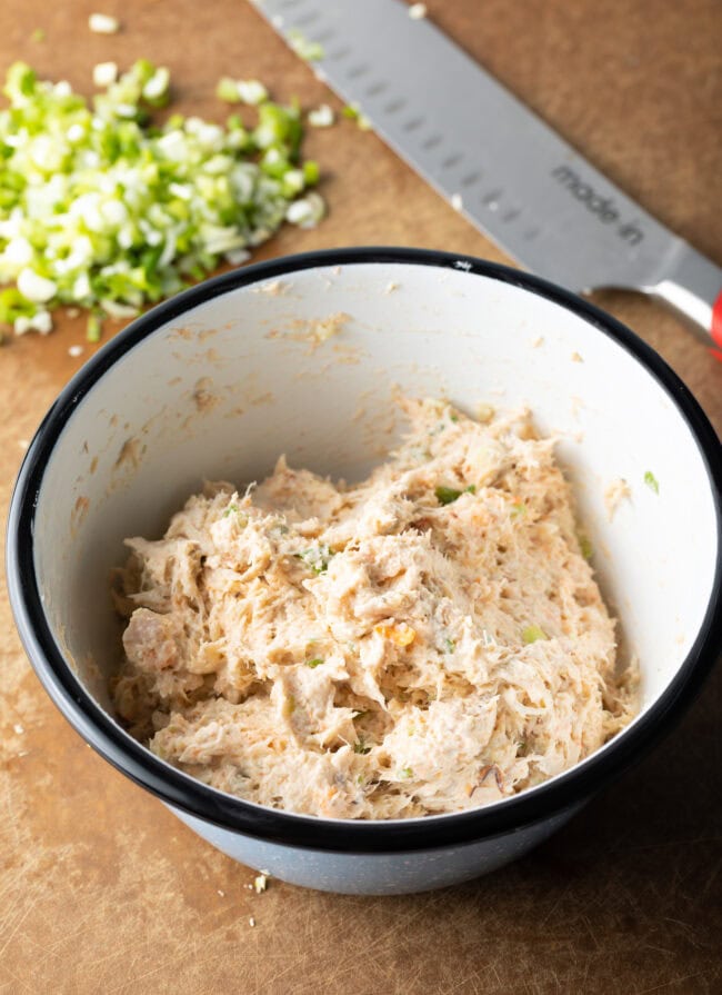 White bowl with seafood filling mixture for stuffed mushrooms.