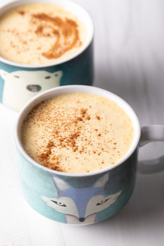 Two mugs of Vietnamese egg coffee with egg froth on top.