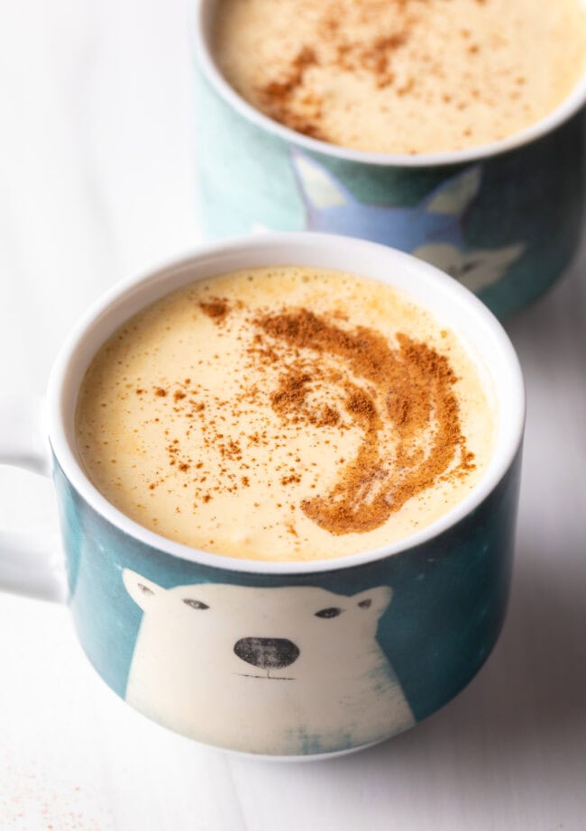 Two mugs of Vietnamese egg coffee with cinnamon on top