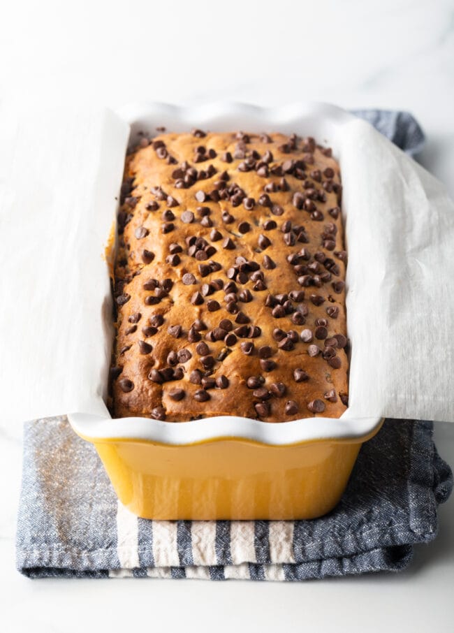 Ice cream bread with chocolate chips in a yellow ceramic baking pan loaf.