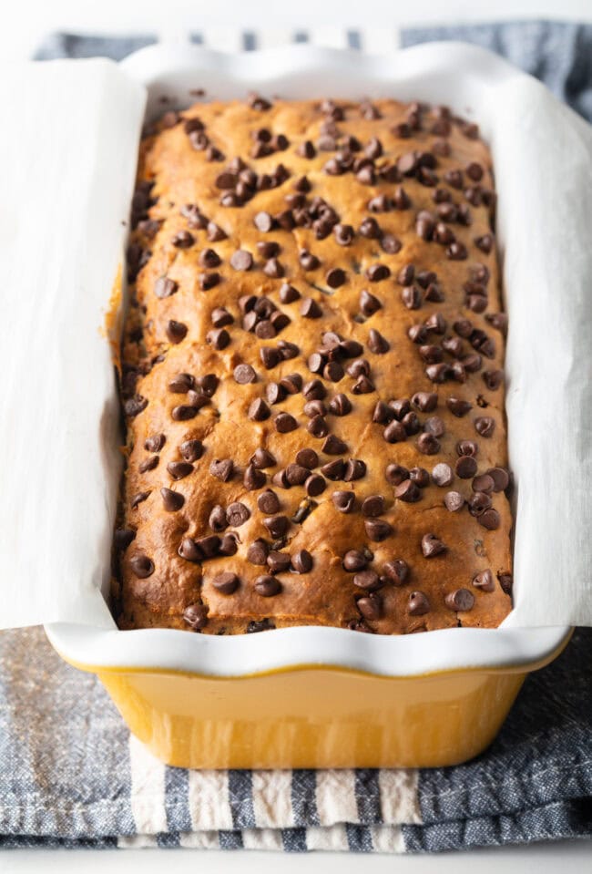 Ice cream bread with chocolate chips in a yellow ceramic baking pan loaf.