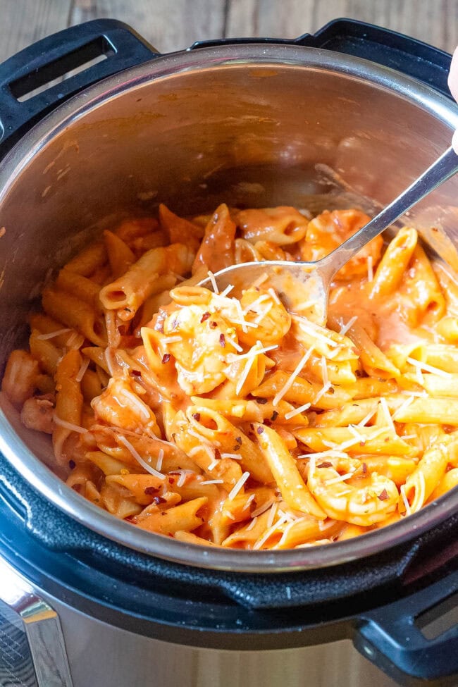 Shrimp pasta with vodka sauce in an instant pot with a spoon in the pot. 