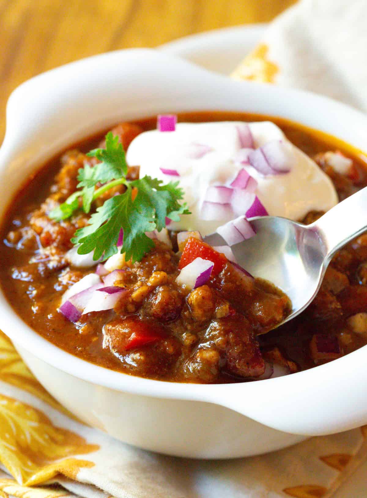 spoon in chili bowl with toppings