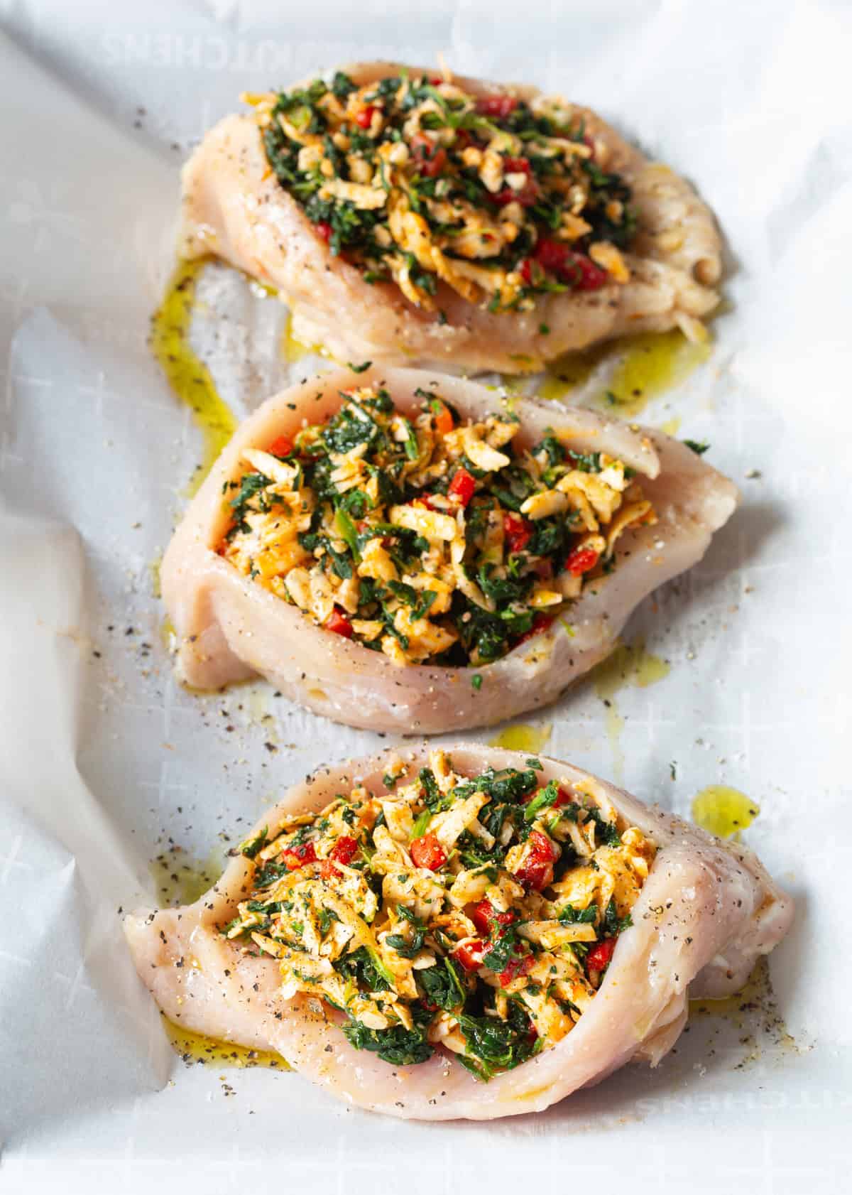 raw chicken pieces with filling pressed inside the cavity