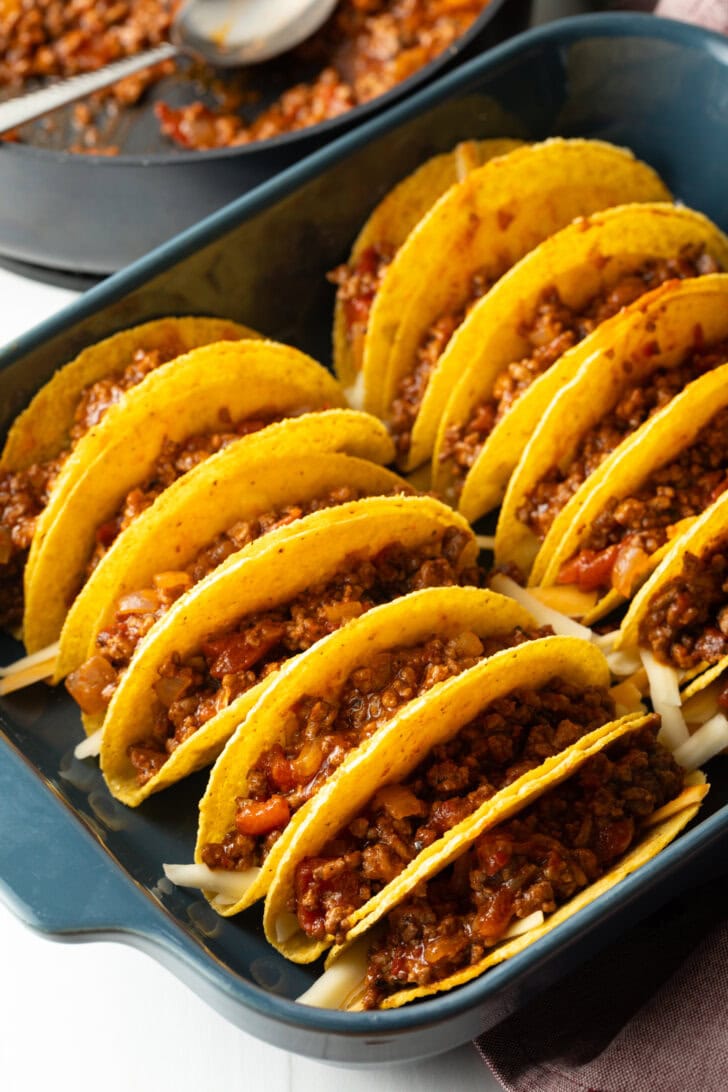 Ground beef mixture added to yellow corn tortilla shells.